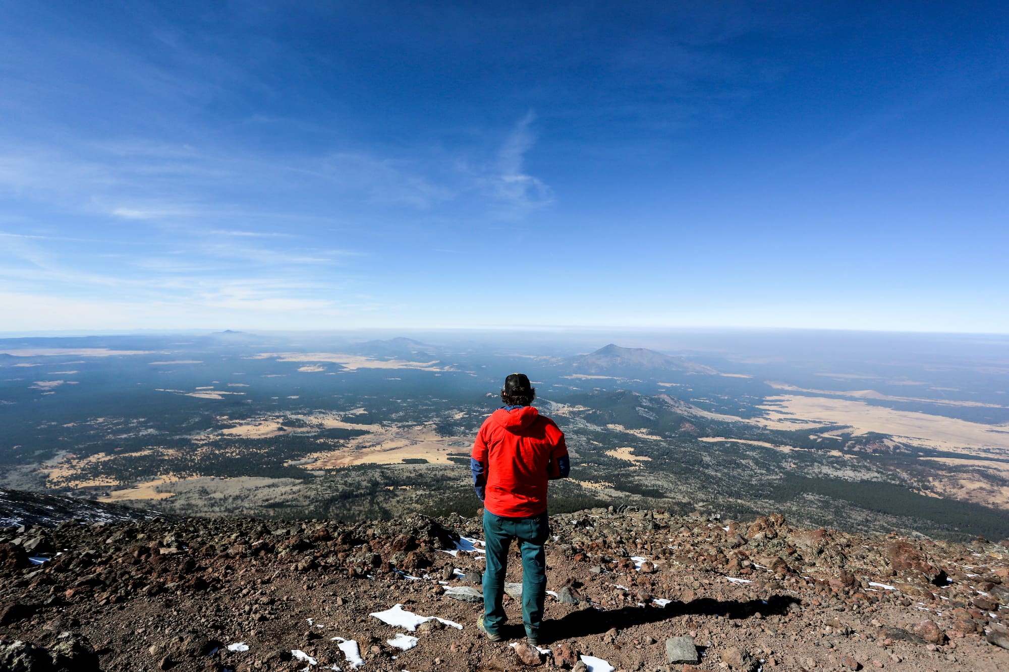 man standing on mountain overlooking landscape