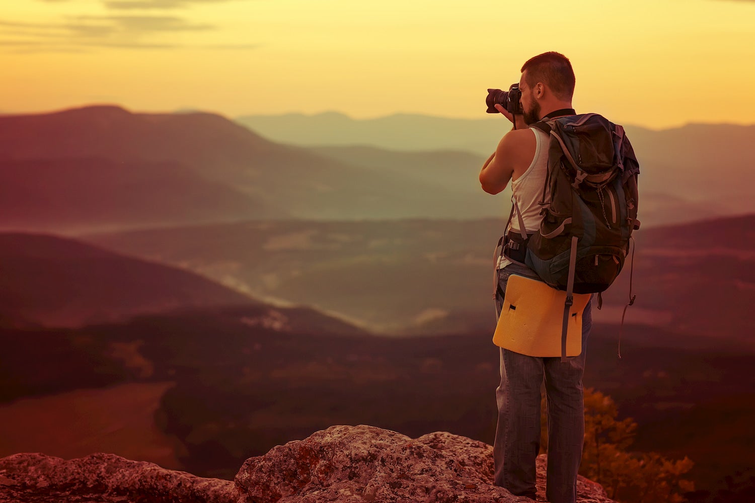 man on mountian doing landscape photography
