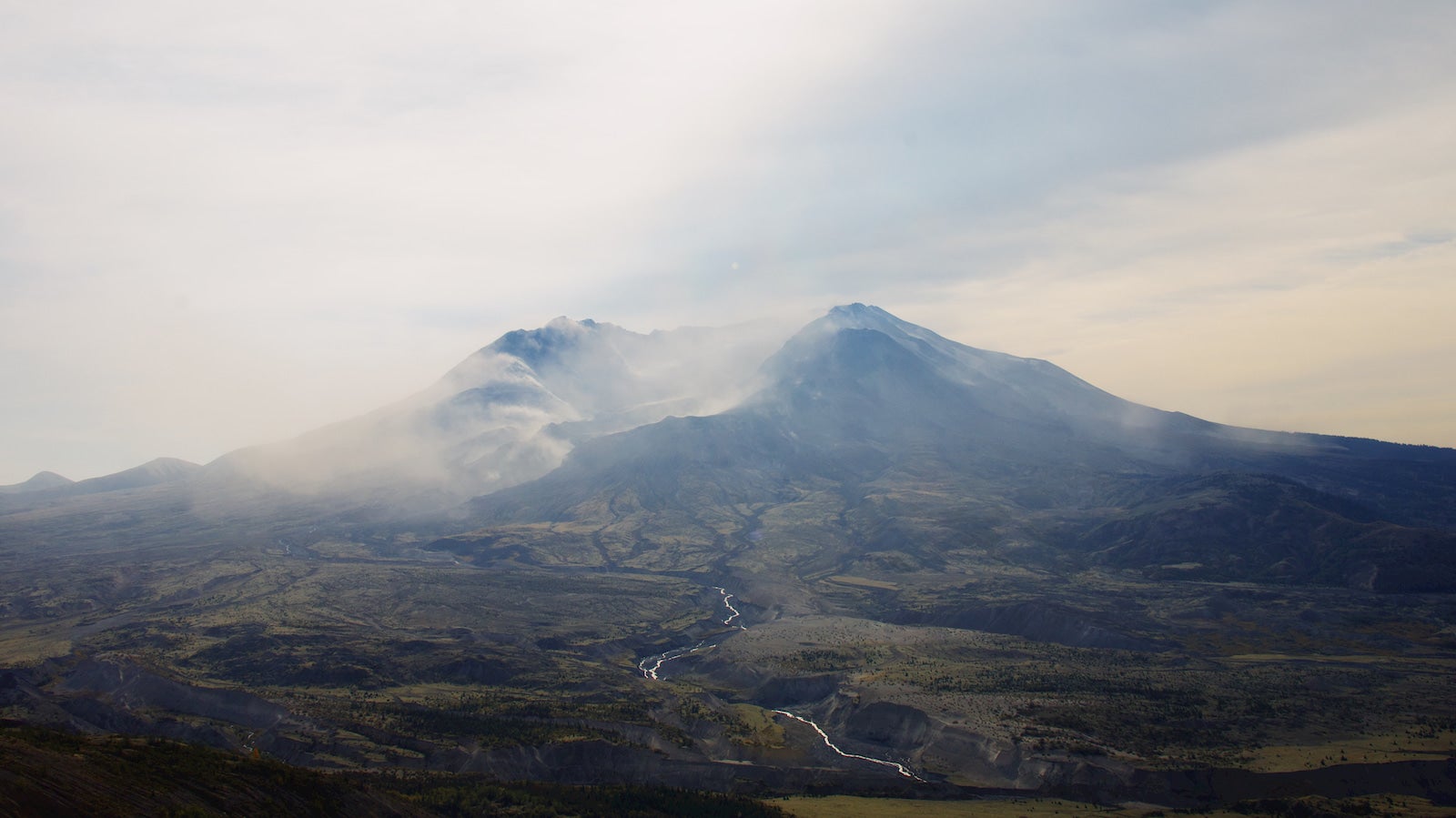 Fog over a hollow crater shaped mountain.