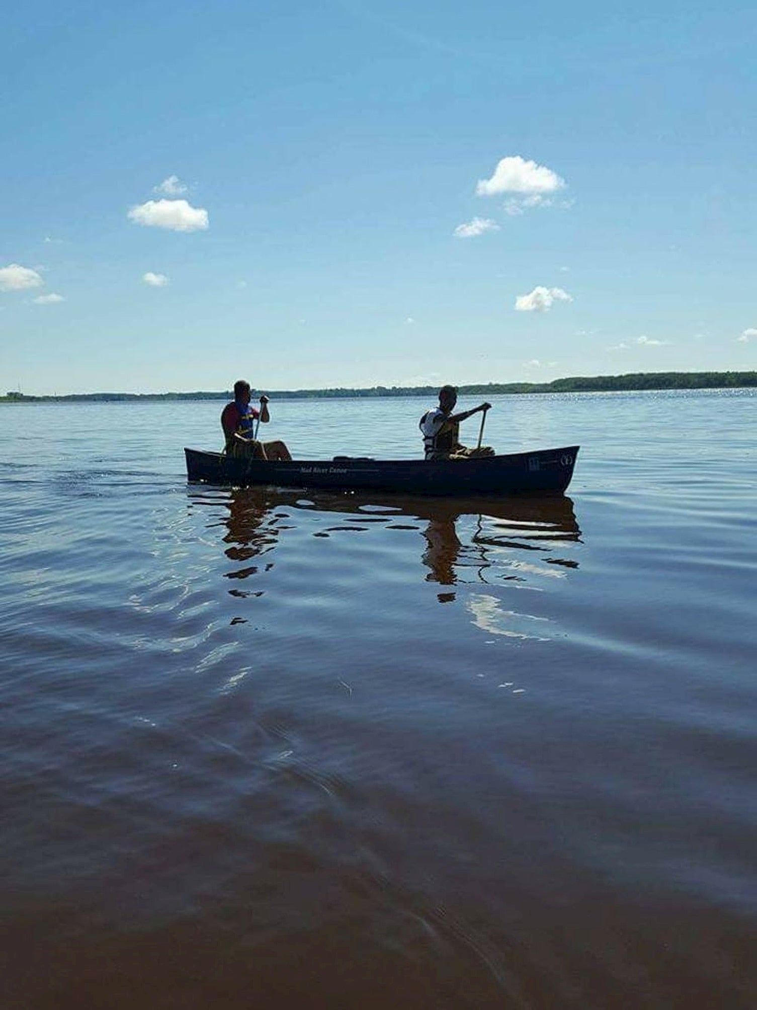 Two people canoeing on a lake.