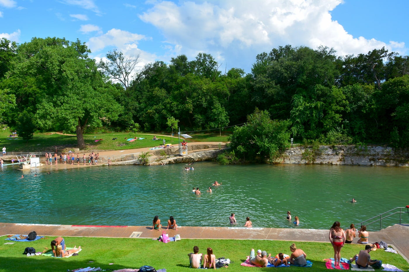 Outdoor pool surrounded by bathers.