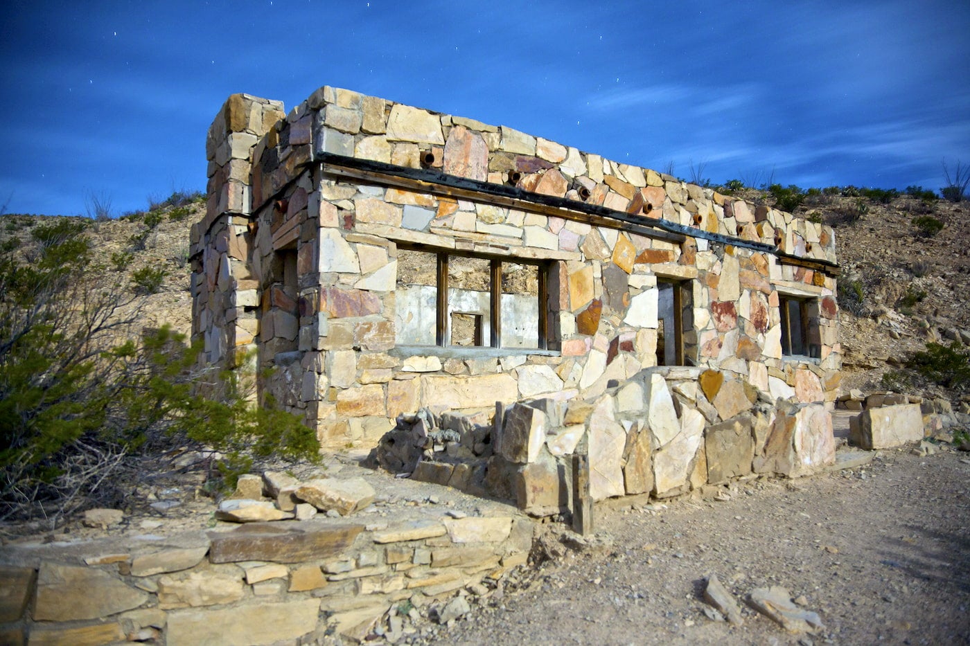 Edifício de pedra no deserto com janelas ocas.