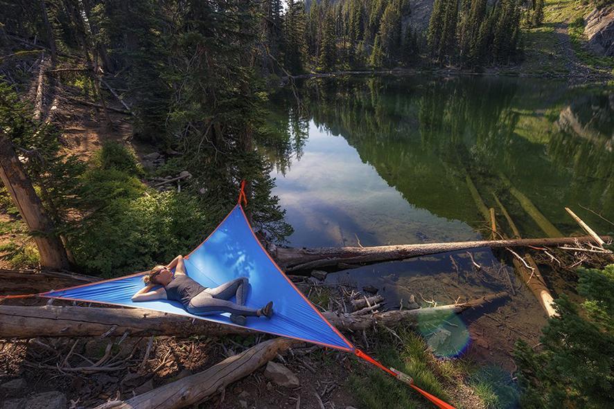 Person sleeping in a tent over a lake 