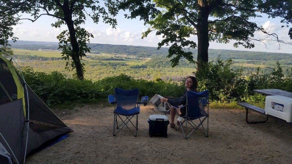 Women relaxing in camp chair ion shaded area in front of large panoramic view of a valley