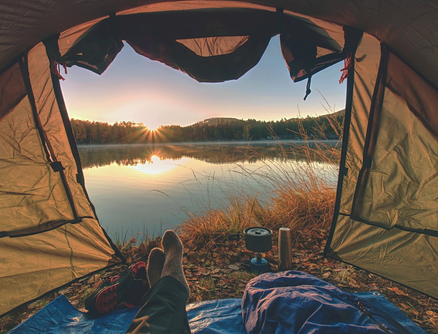 backpacker relaxing in tent with breakfast