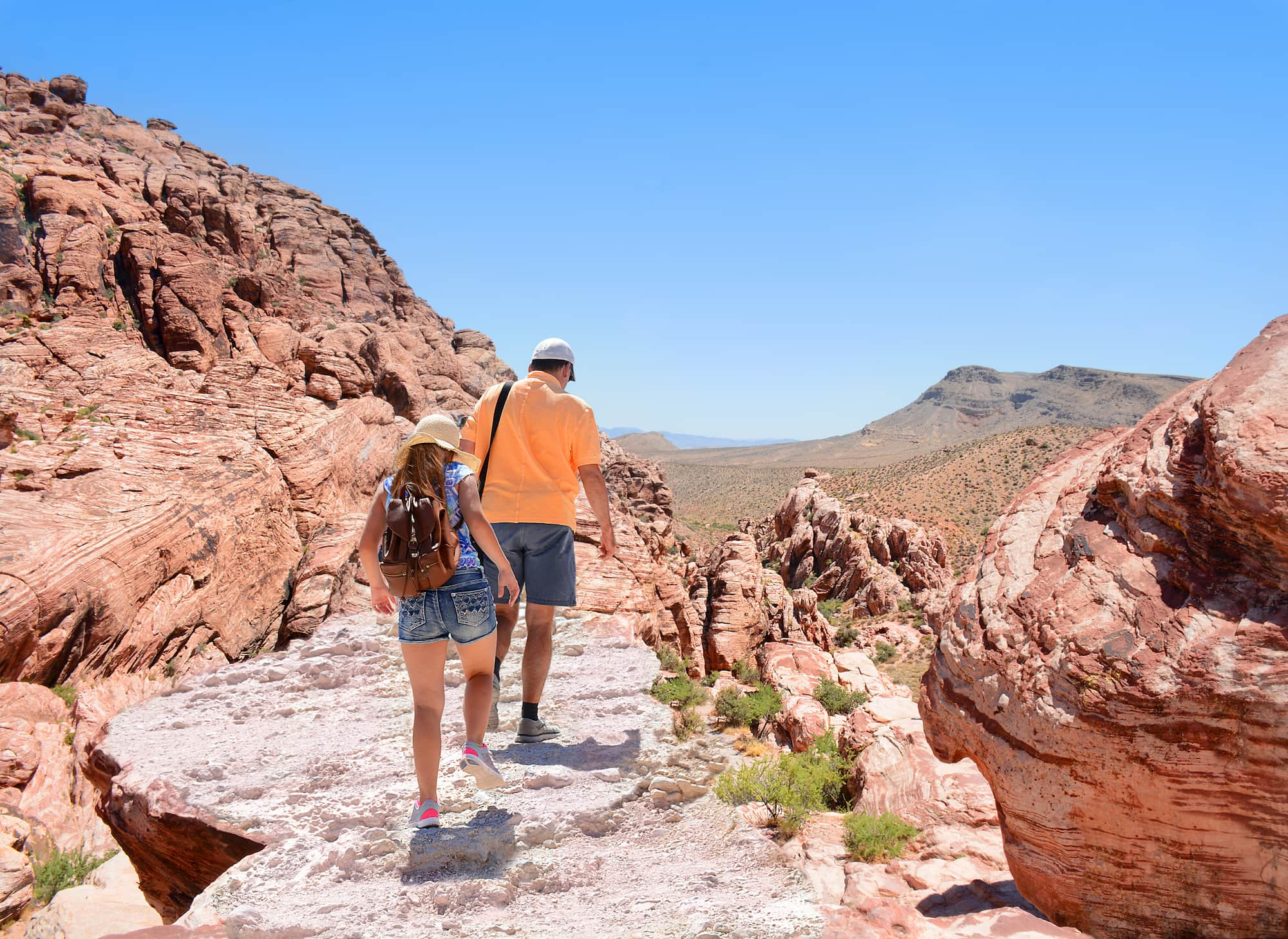 people hiking near red rocks