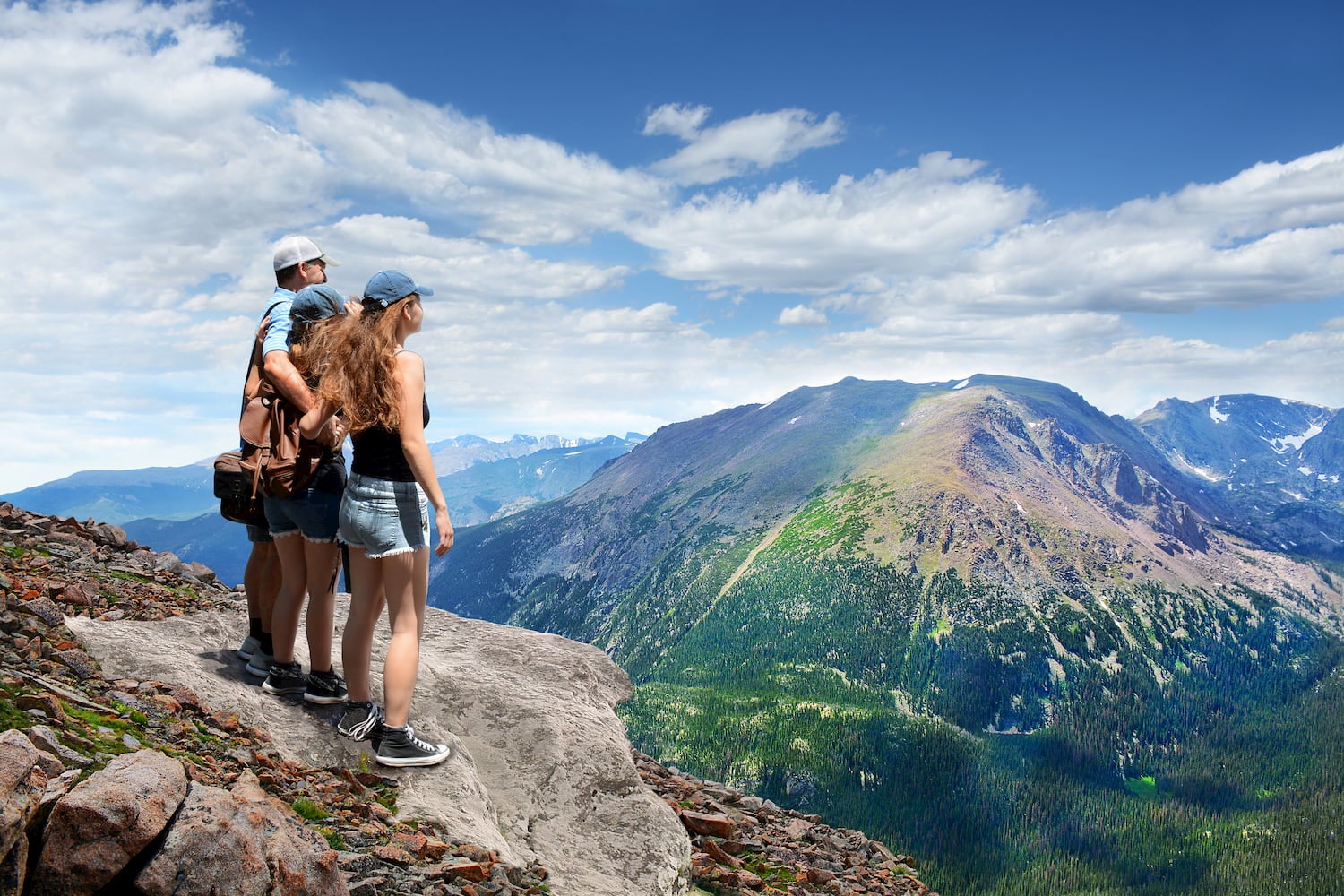 group of people hugging overlooking mountains