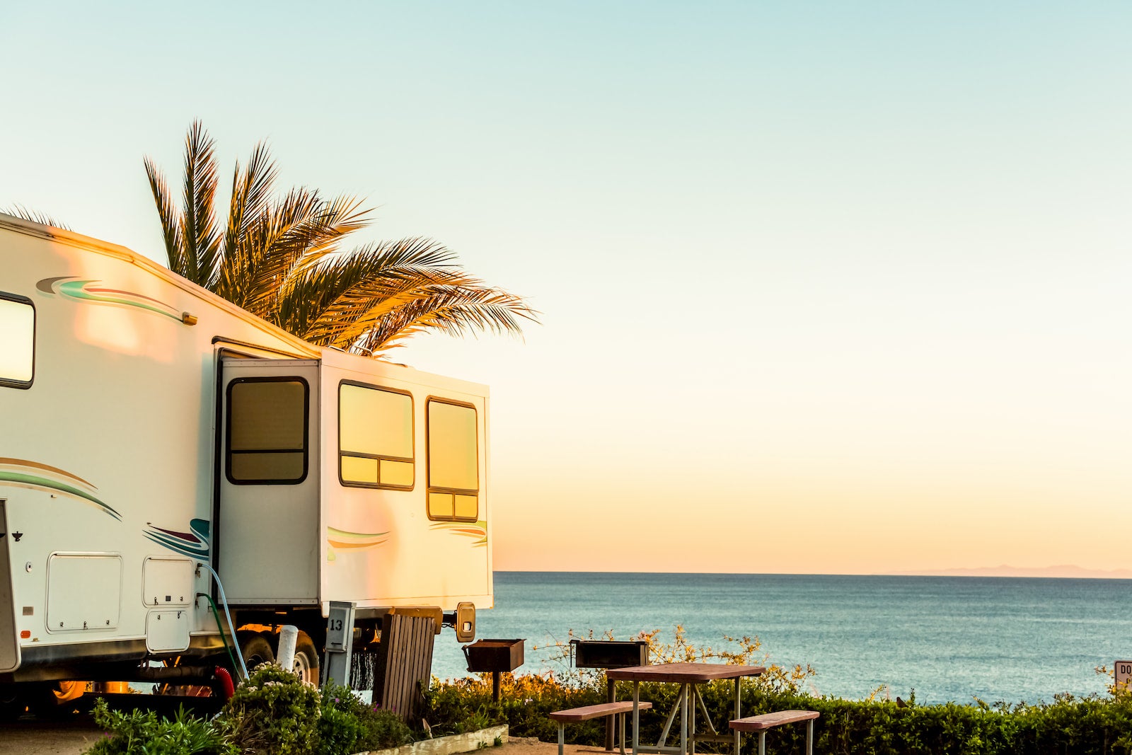 RV with slide out side parked on the beach.