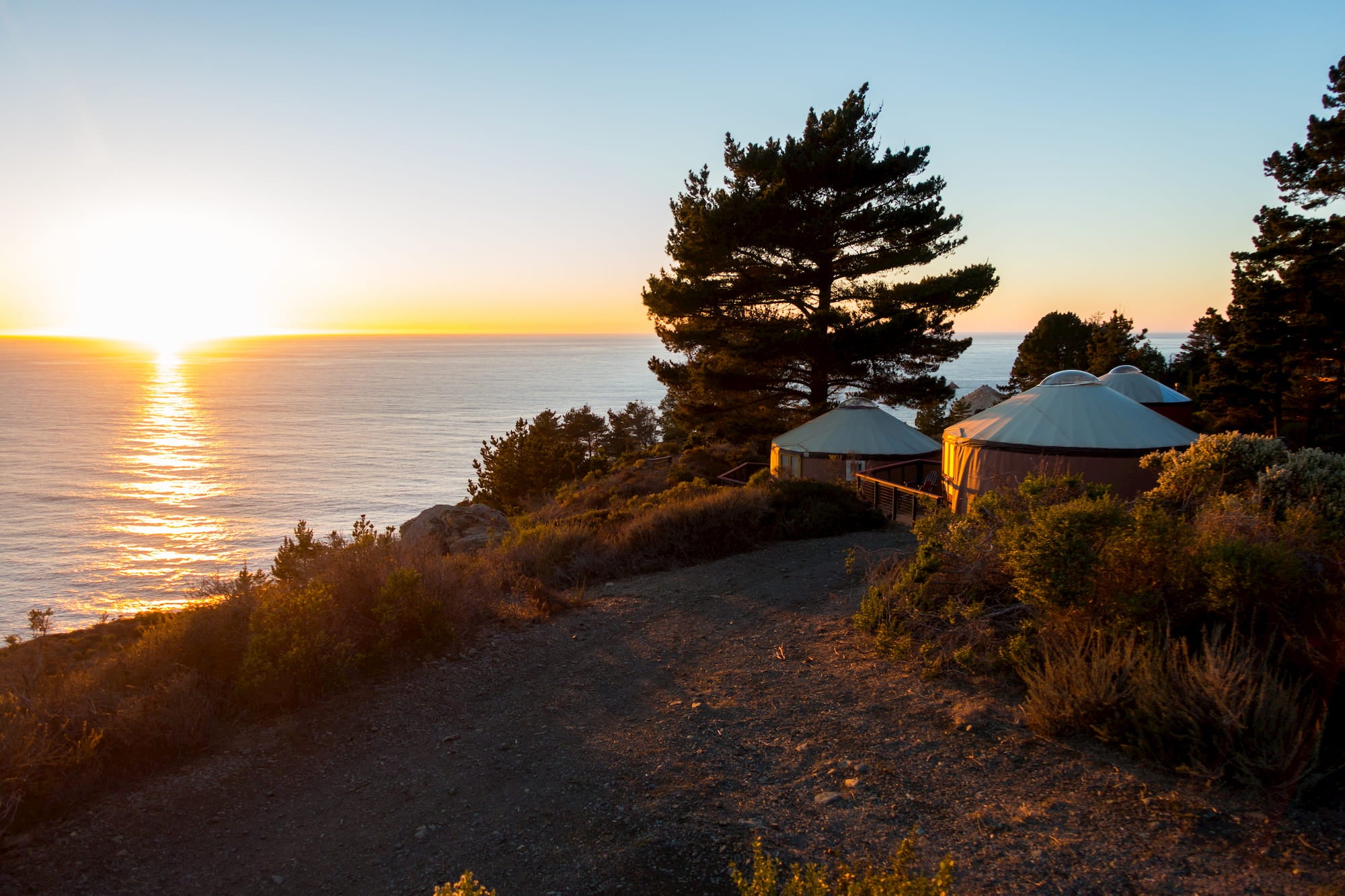 Glamping yurts on the coast of Big Sur at sunset.