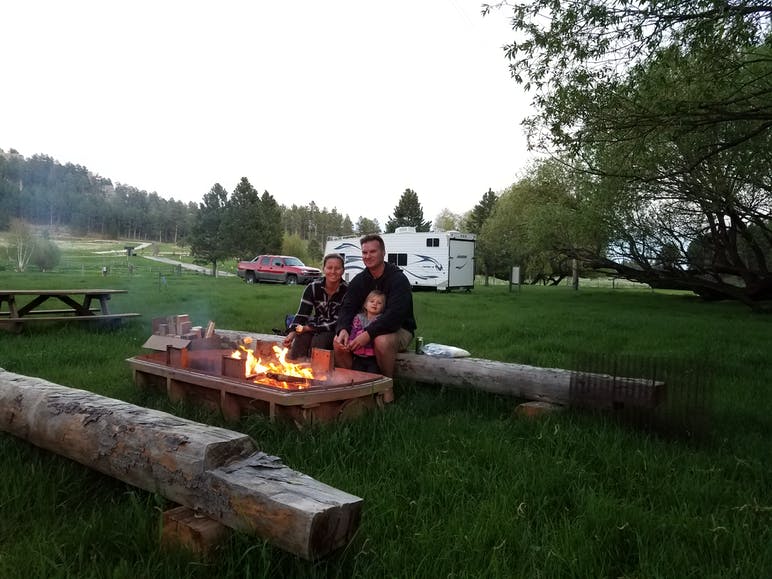 camp guests sitting around a campfire