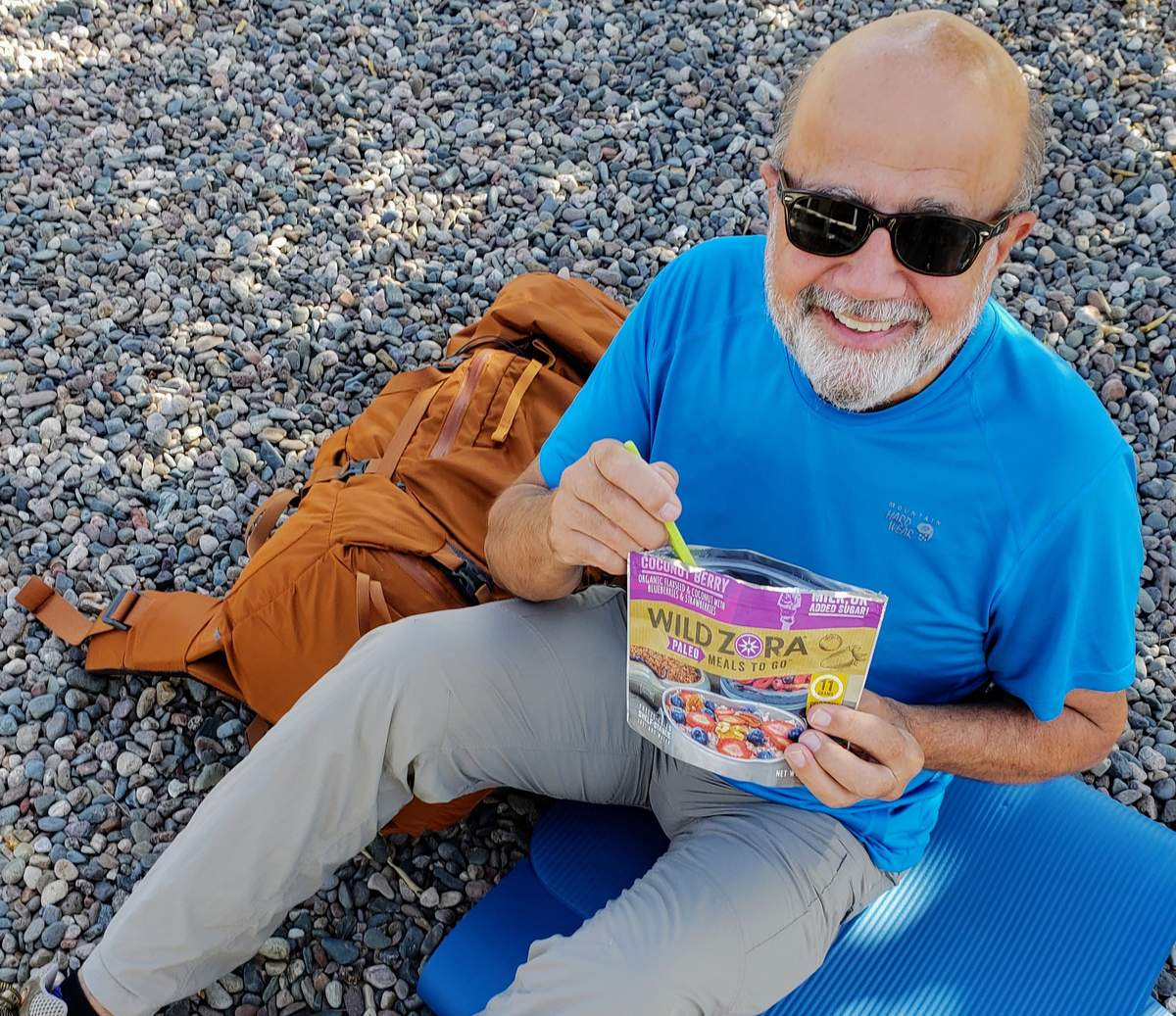 man sitting on ground eating food