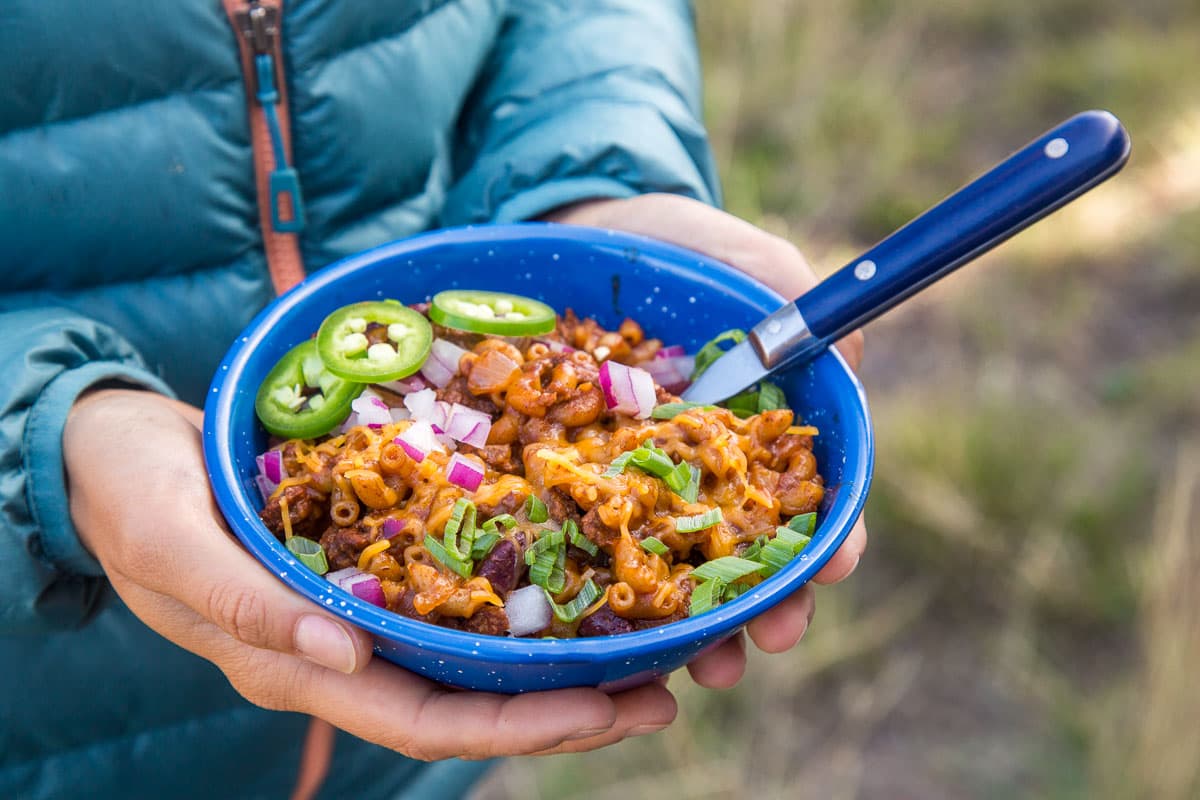 Camping bowl filled with chili mac, perfect for fall camp cooking.