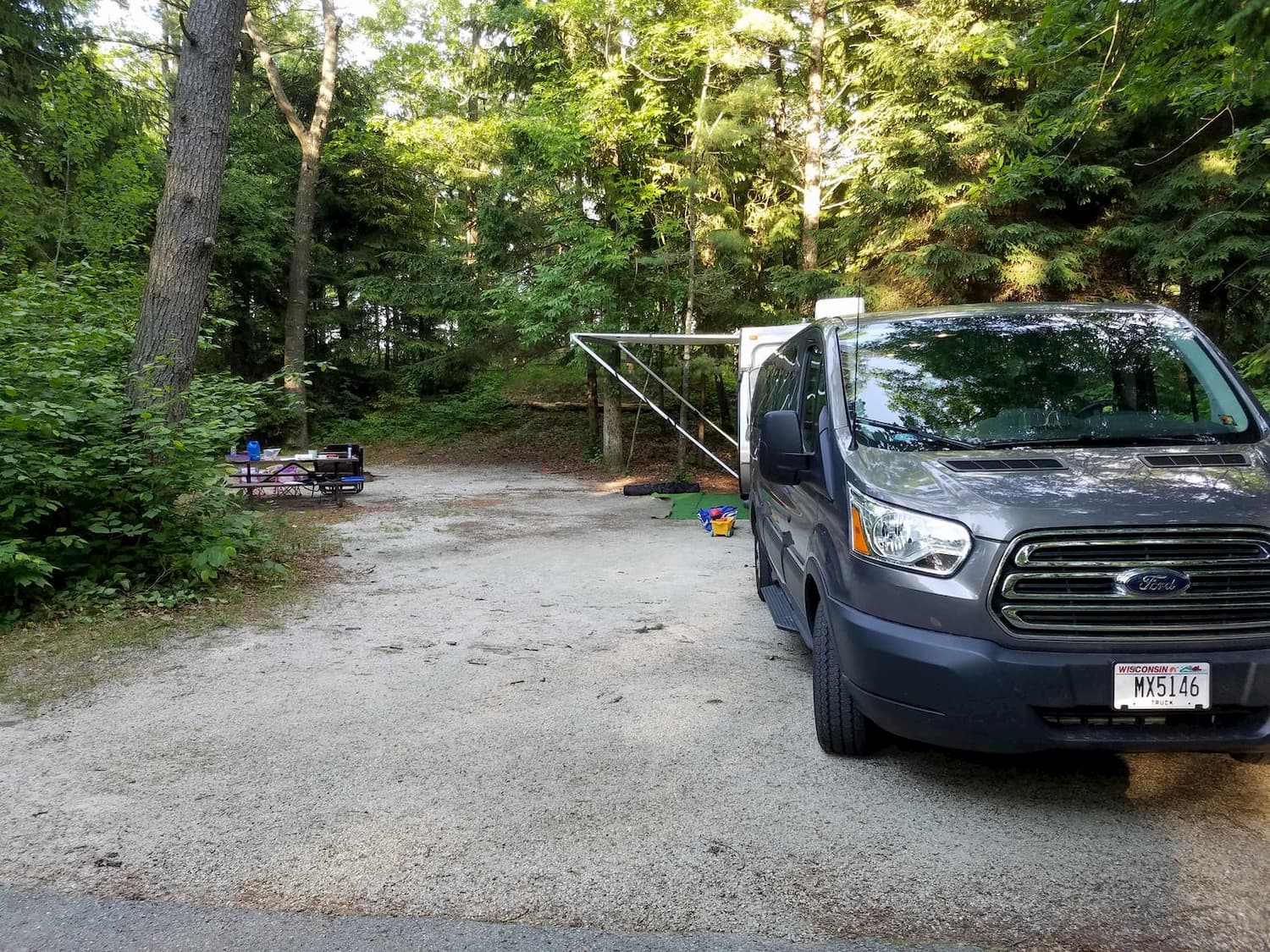 van parked at forested campsite