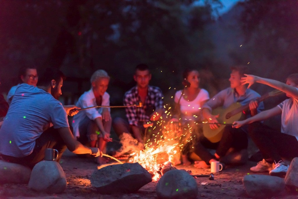 Group of campers gathered around a fire.