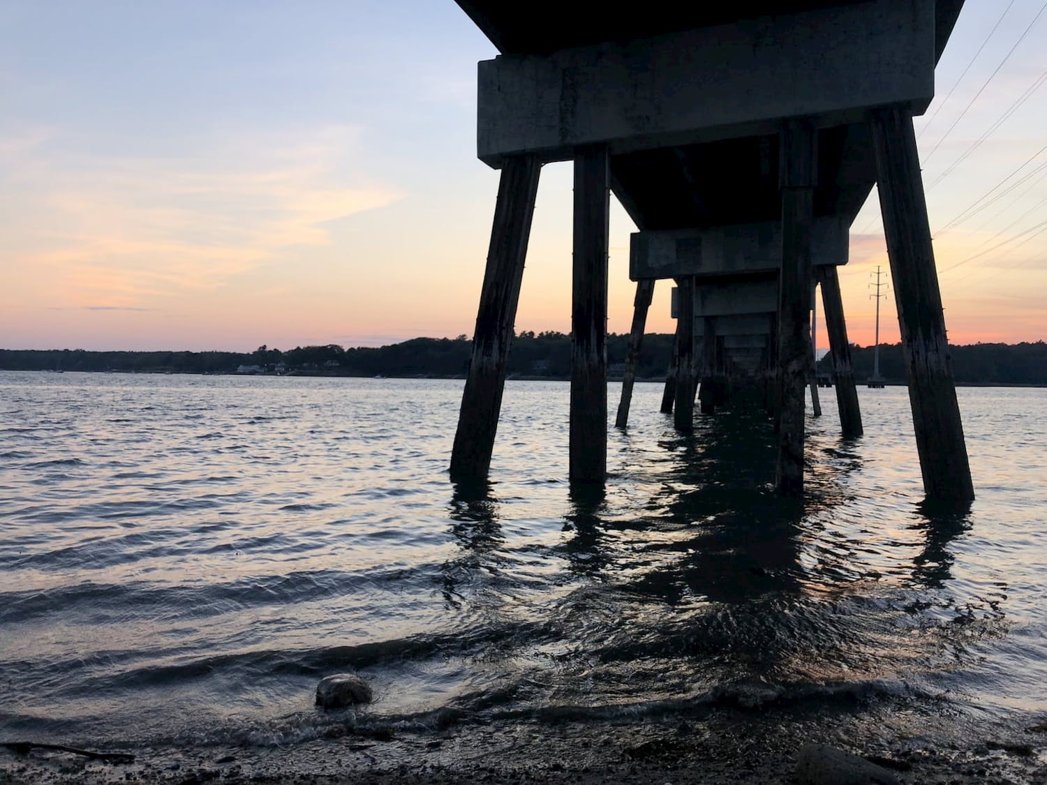 sunset view from under a pier and over the water