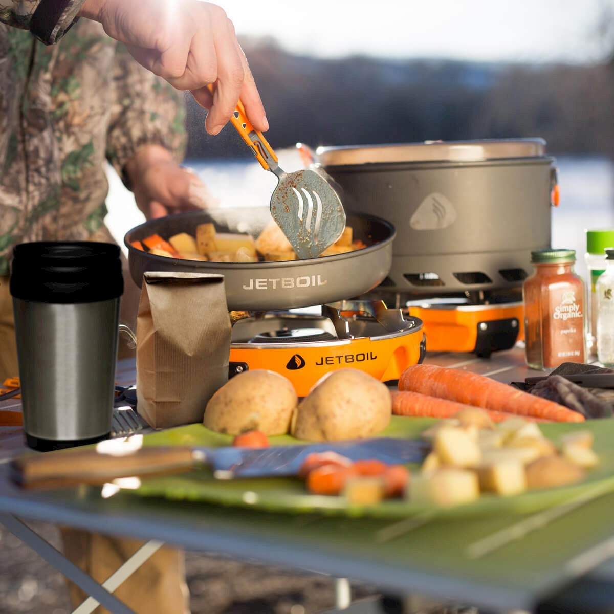 person cooking food on jetboil genesis