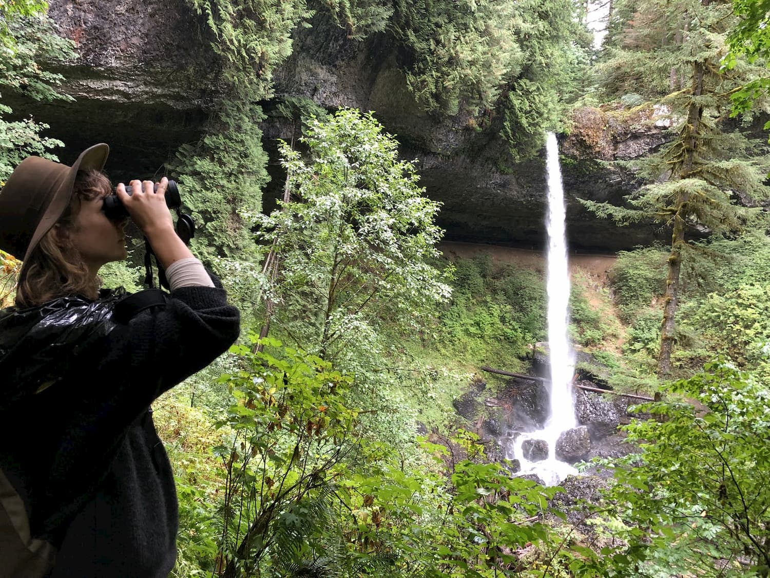 woman with binoculars looking at waterfalls