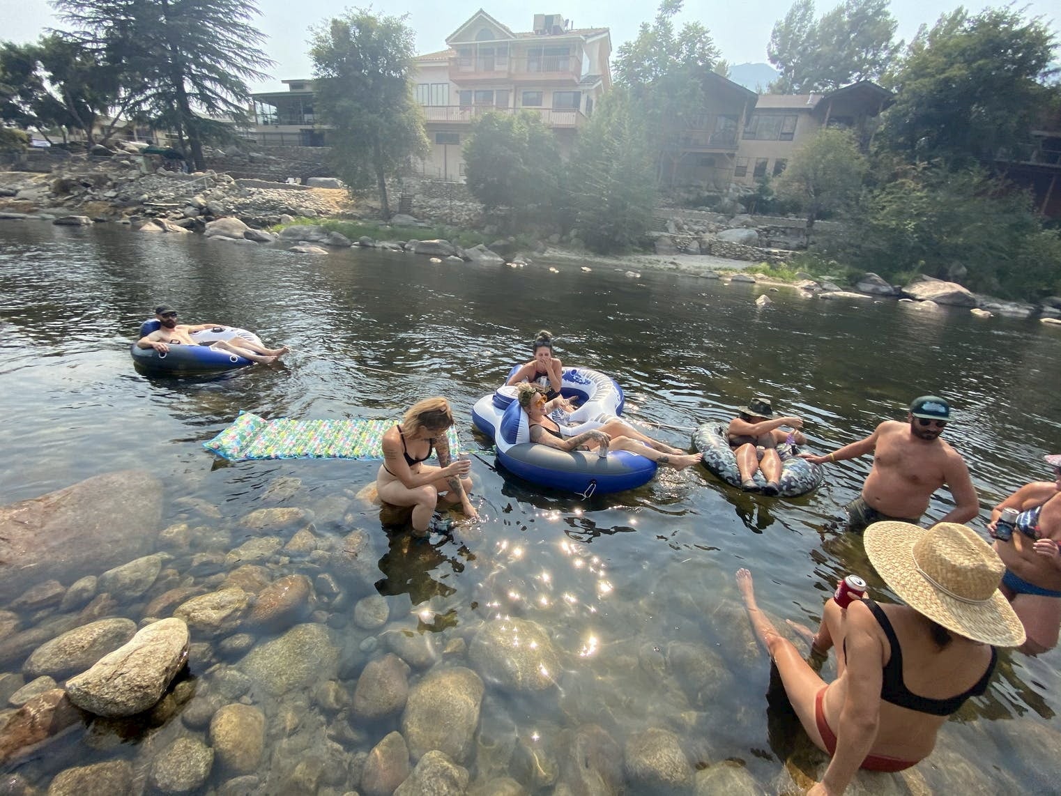 Group of friends hanging out in tubes in a river in California.