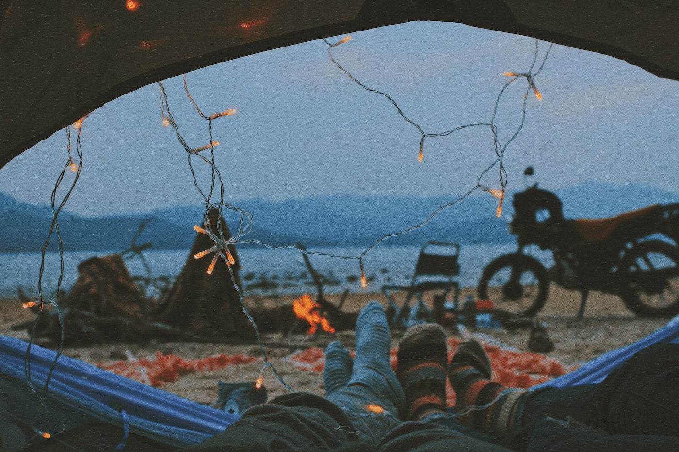 A couple cuddling while camping near mountains.