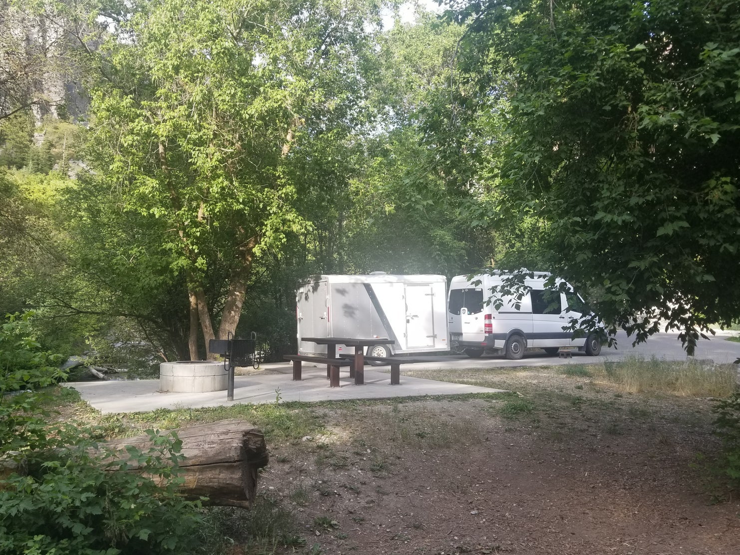 van parked at campsite with trailer