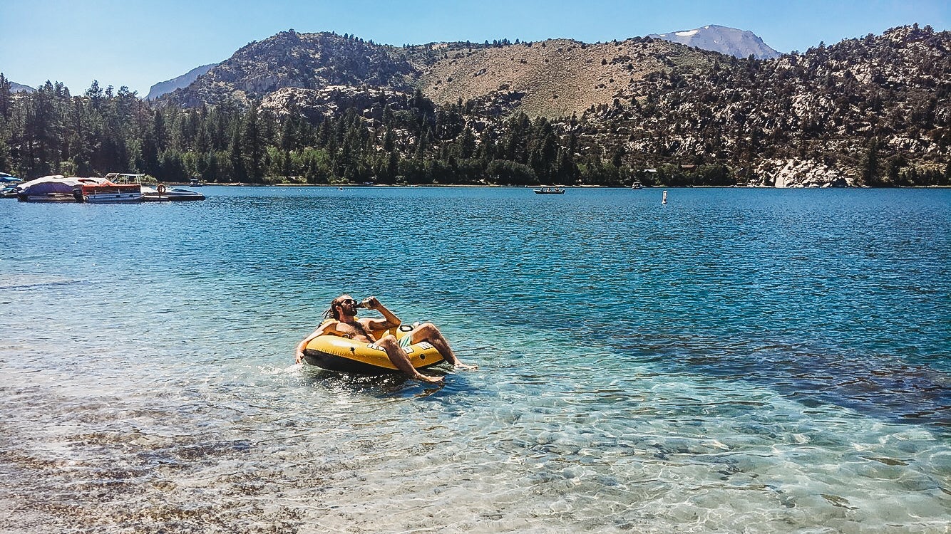 man in floaty on blue lake