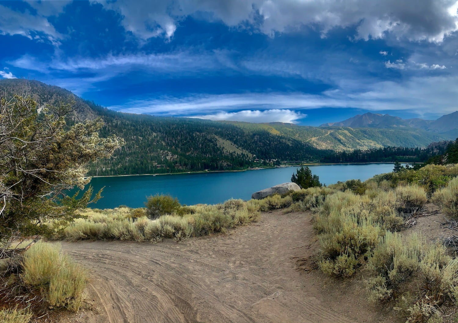road and lake during cloudy storm