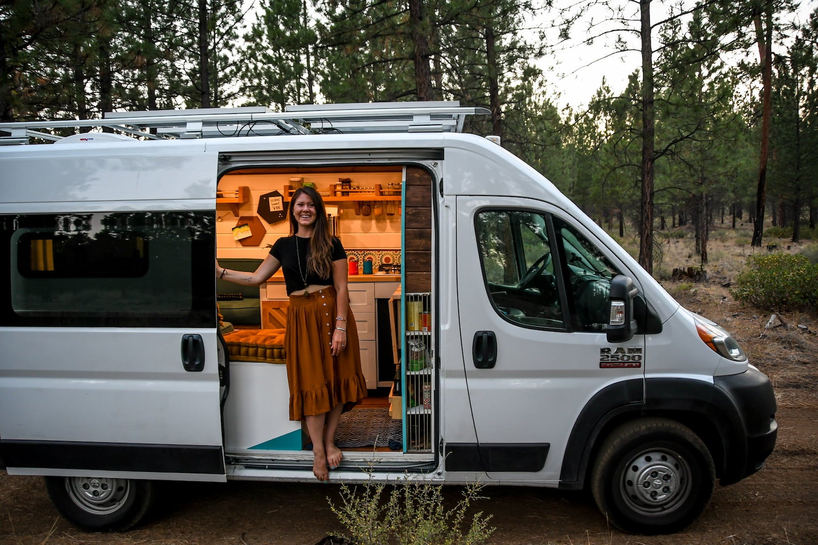 Katie of Two Wandering Soles standing in her van.