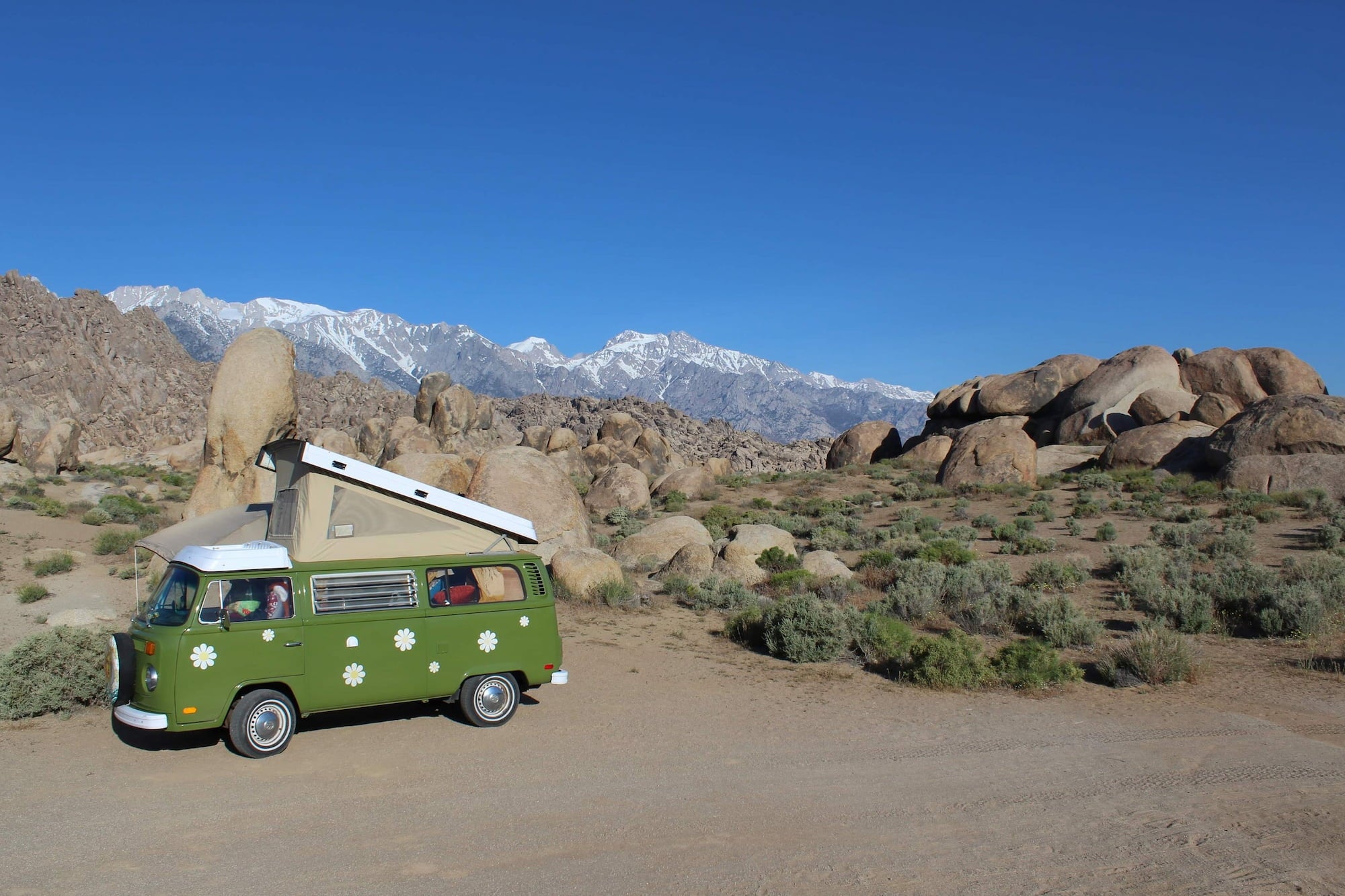 Green VW van with polka dots and pop up tent parked in the desert below Alabama hills.