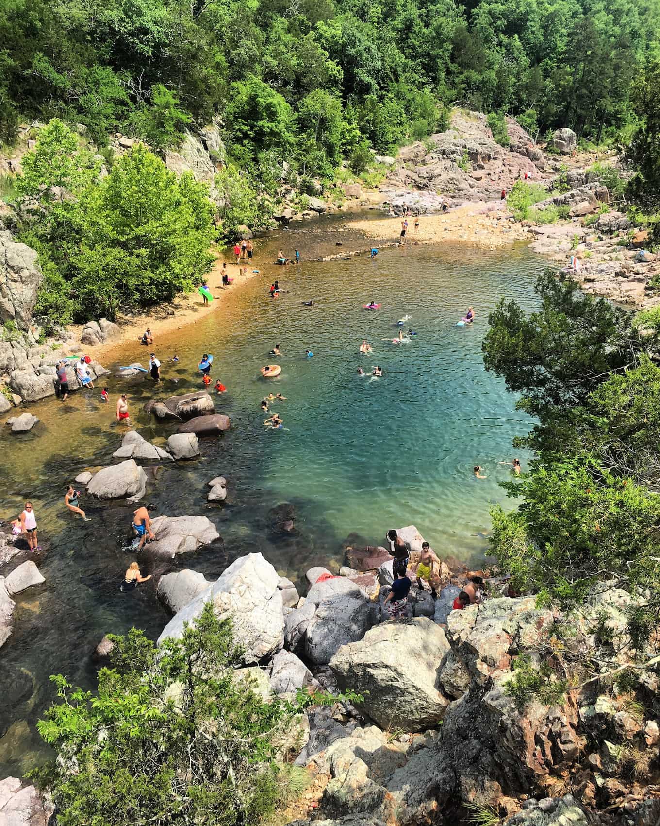 Aerial image of blue waters with a group of people wading and soaking.
