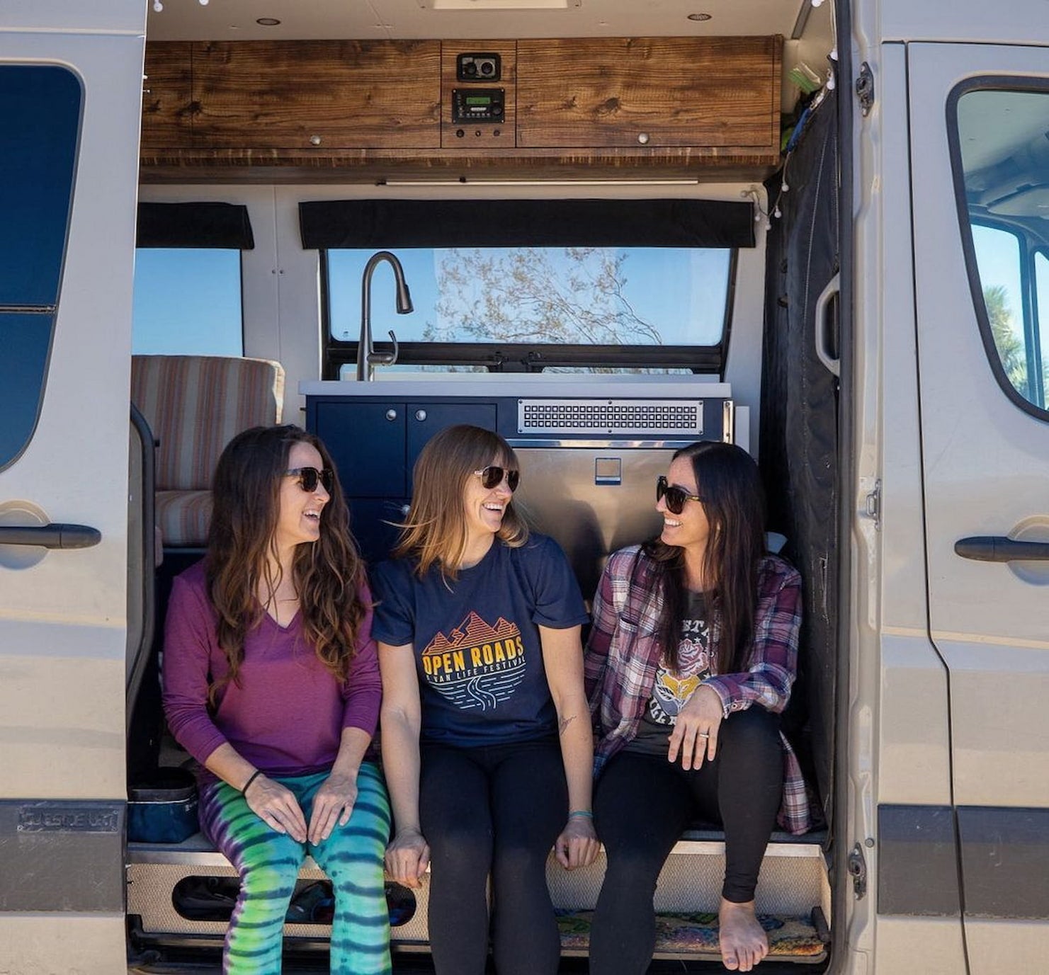 Group of women hanging out in a camper van.