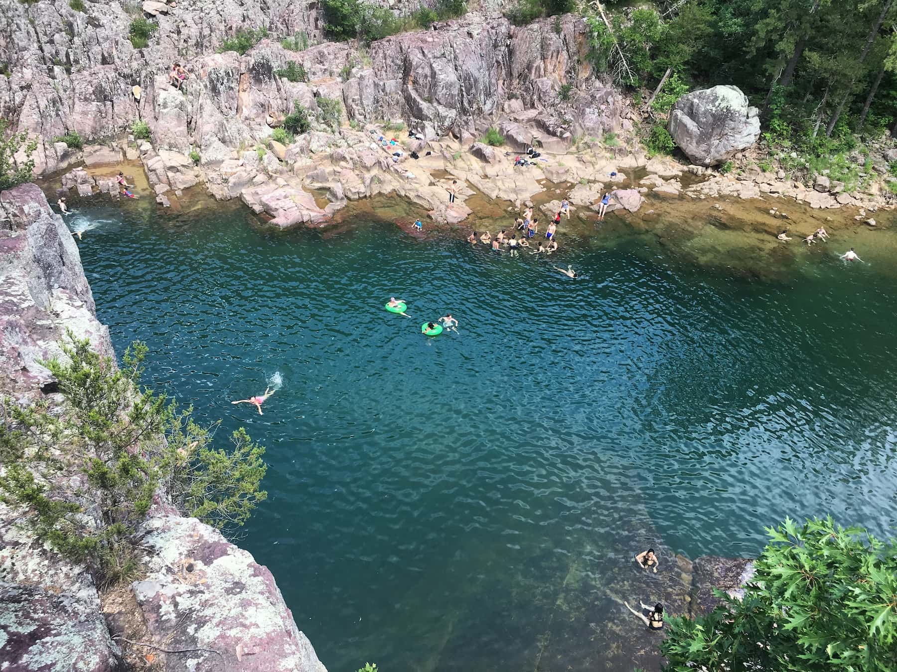 View overlooking the blue water of the Johnson Shut Ins with swimmers below.