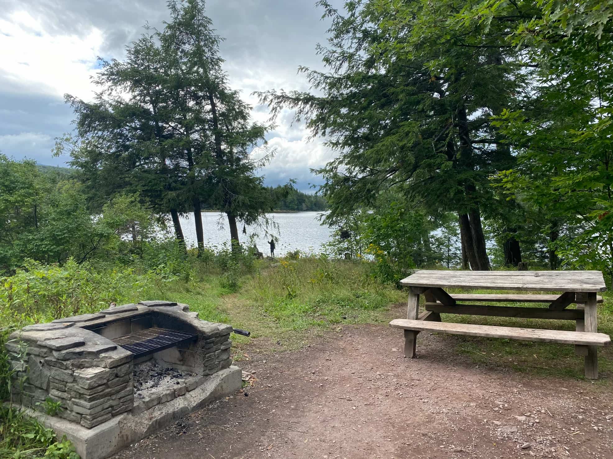Rock sided fire pit and picnic table at campsite overlooking North-South Lake.