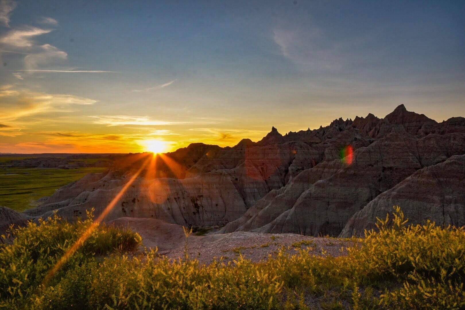 Sunsetting over the rock formations in the badlands in front of a wildflowers.
