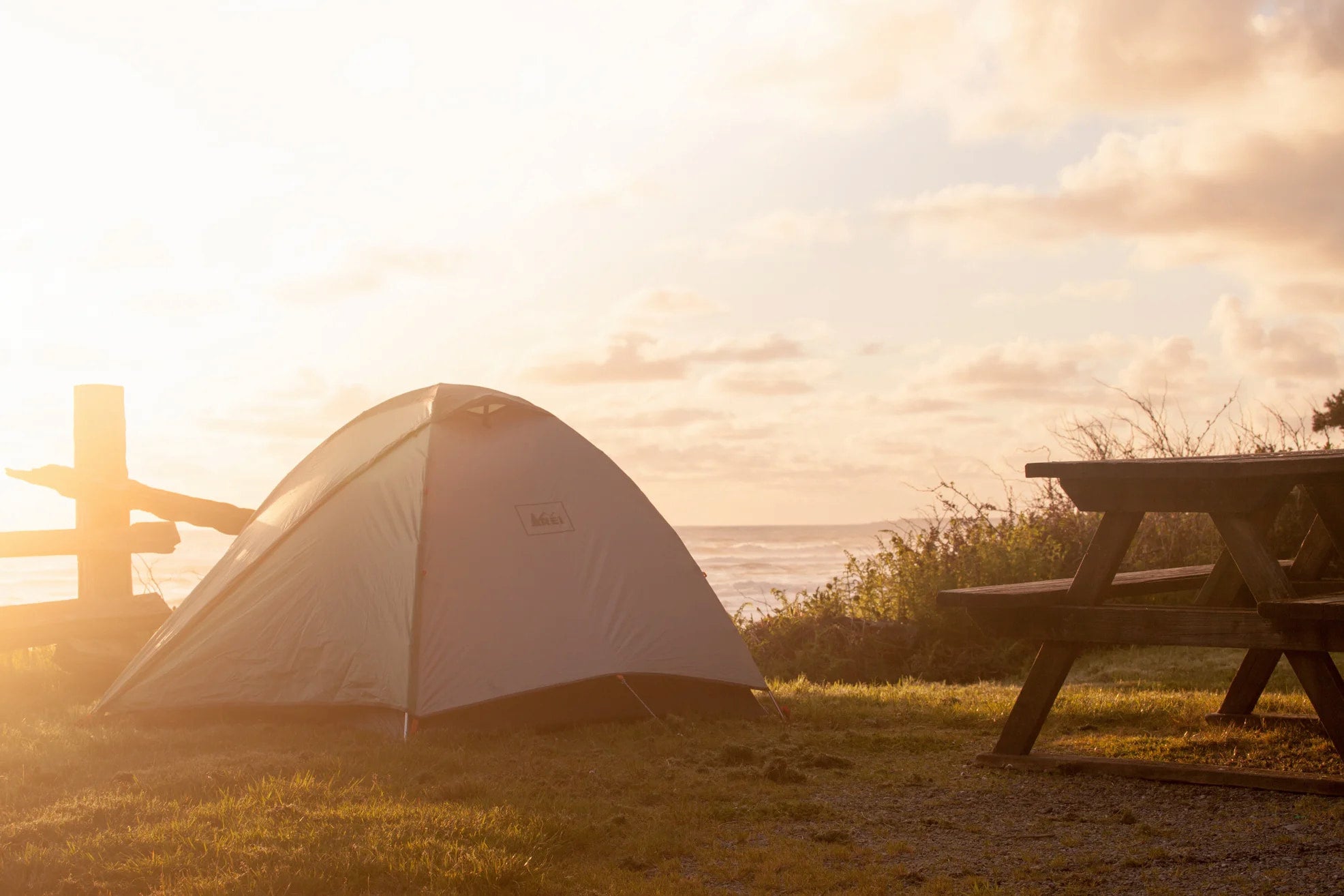 Sunlight beaming over an oceanside campsite along the pacific coast.