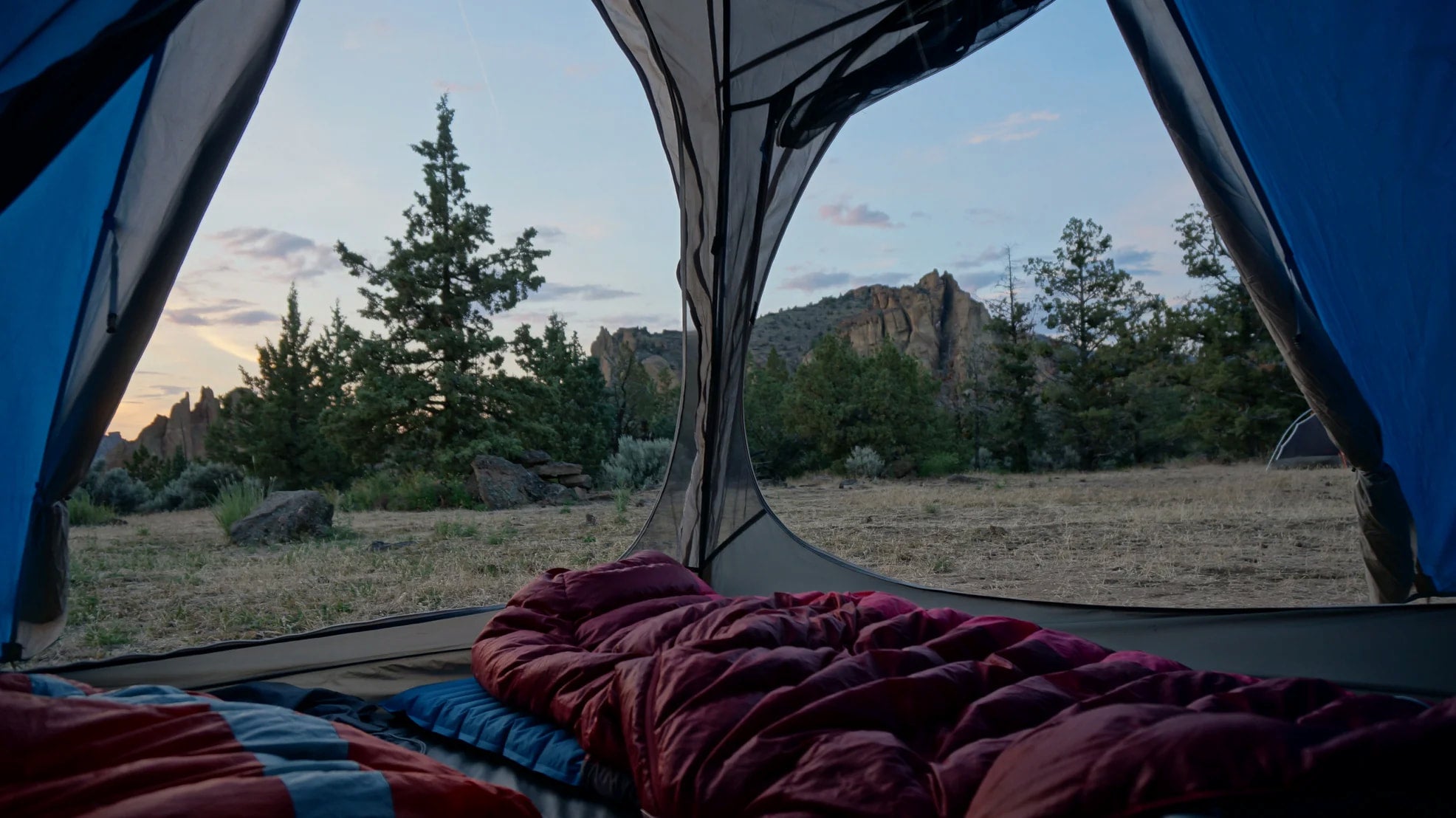 View from inside a tent overlooking the rock formations at smith rock state park at dusk.