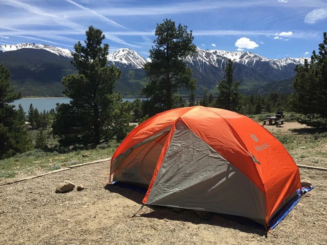 Campsite with tent and views of snowy mountains